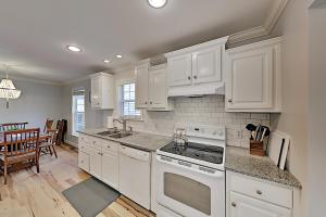 a kitchen with white cabinets and a stove top oven at Brownstone Escape in Asheville