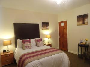 a bedroom with a bed with a large black headboard at Orley House B&B in Drogheda