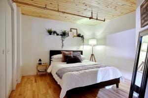 sypialnia z dużym łóżkiem i drewnianym sufitem w obiekcie Lion's Den // Spacious 1500 sqft (2 WC) - Downtown w mieście Quebec City
