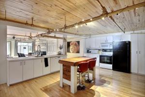 魁北克市的住宿－Lion's Den // Spacious 1500 sqft (2 WC) - Downtown，厨房配有桌子和黑冰箱。