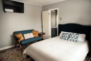 - une chambre avec un lit et une chaise bleue dans l'établissement Charming French Studio Apartment, à Laramie