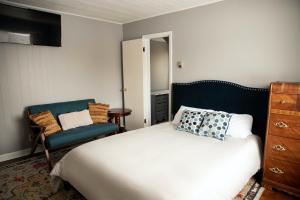 - une chambre avec un lit et une chaise dans l'établissement Charming French Studio Apartment, à Laramie