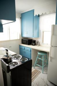 La cuisine est équipée de placards bleus et d'un four avec plaques de cuisson. dans l'établissement Charming French Studio Apartment, à Laramie