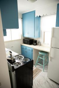 a kitchen with blue cabinets and a stove top oven at Charming French Studio Apartment in Laramie
