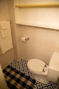 a bathroom with a white toilet and a checkered floor at Charming French Studio Apartment in Laramie
