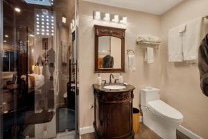a bathroom with a toilet, sink, and mirror at Quiet Mind Mountain Lodge, Retreat & Spa in Julian