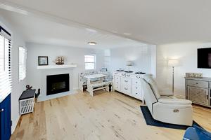 a white living room with a fireplace and a chair at Sandyhill Sun in Ocean City