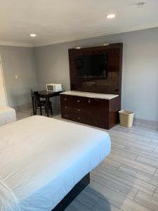 a hotel room with a bed and a desk and a television at Willow Tree Inn & Suites in Sun Valley