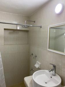 a white bathroom with a sink and a mirror at Departamento Colibrí in Cozumel