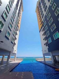 dos edificios altos junto a un cuerpo de agua en ORKED VANDA, 3 Bedroom apartment, SEAVIEW NETFLIXWIFIYOUTUBE, en Kuala Terengganu