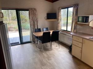 a kitchen with a table and chairs and a refrigerator at Victoria Lake Holiday Park in Shepparton