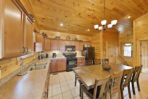 uma cozinha com uma mesa e um tecto de madeira em Gatlinburg Falls Cabin Unit 812 em Gatlinburg