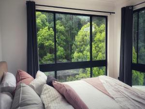 Currumbin ValleyPvc的一间带床和大窗户的卧室