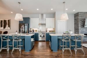 een keuken met blauwe kasten en barkrukken bij Southside Manor in Nashville