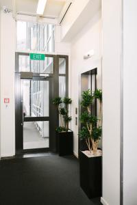 an exit sign in an office with potted plants at Gilmer Apartment Hotel in Wellington