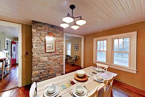 a dining room with a table and a stone wall at Acorn House in Fletcher