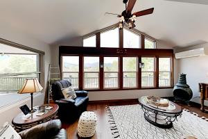 uma sala de estar com um lustre e uma grande janela em Peaks Oasis em Lake Lure
