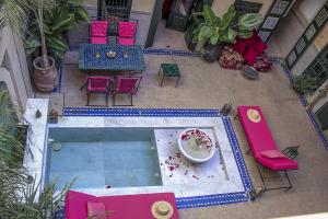 an overhead view of a pool with a table and chairs at Riad Dar Habiba by Garden Wonders in Marrakech