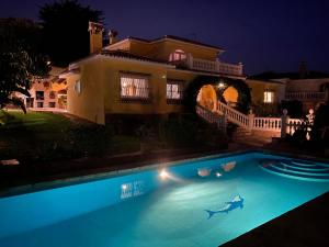 a swimming pool in front of a house at night at Rustic spanish villa Saltwater Pool in Benalmádena