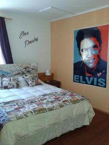 a bedroom with a bed with a poster of obama at Hotel Ecomusic in Valparaíso