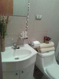 a bathroom with a sink and a toilet with towels at Hotel Ecomusic in Valparaíso