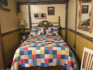 a bed in a room with a quilt on it at The General Store Charming Suite Themed 1890s Acorn Hideaways in Canton