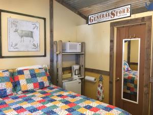 a bedroom with a bed with a quilt on it at The General Store Charming Suite Themed 1890s Acorn Hideaways in Canton