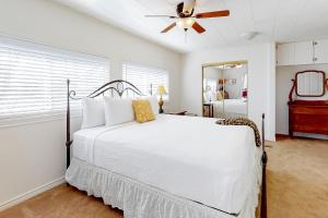 1 dormitorio con cama blanca y ventilador de techo en Antler Hill, en Kerrville