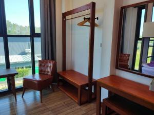 ein Zimmer mit einem Spiegel, einem Schreibtisch und einem Stuhl in der Unterkunft Dream riverside in Ban Rai