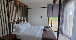 1 dormitorio con cama con dosel y ventana en Eagle Bay Retreat Borneo Beach Villas Beach Front, en Kumbatang