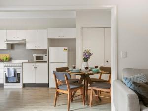 a kitchen and living room with a table and chairs at Finchs Nest in Moss Vale