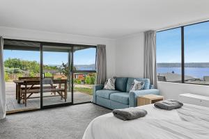 a bedroom with a bed and a couch and a table at Acacia Bay in Taupo