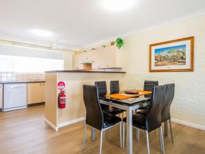 a kitchen and dining room with a table and chairs at Camawood 2 in Iluka