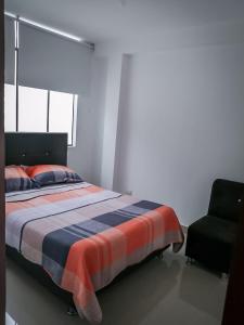 1 dormitorio con 1 cama y 1 silla en Complete apartment, services included, WIFI, Netflix, en Lima
