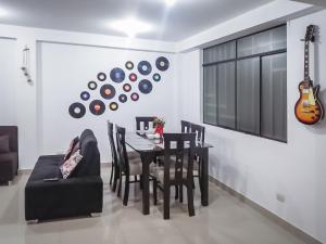 un comedor con una mesa y sillas y una guitarra en la pared en Complete apartment, services included, WIFI, Netflix, en Lima