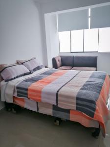 a large bed in a room with two windows at Complete apartment, services included, WIFI, Netflix in Lima