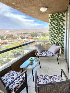balcón con sillas, mesa y vistas en Apartamentos Alma Socoroma, en Arica