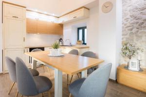 Il comprend une cuisine et une salle à manger avec une table et des chaises en bois. dans l'établissement Villa Stipe - with pool, à Vodenjak