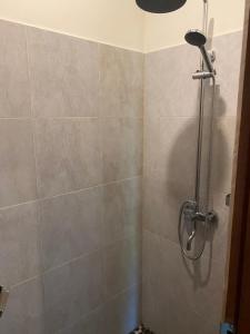 a shower with a shower head in a bathroom at Sambahan Inn in Ubud