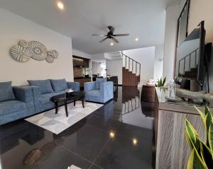 uma sala de estar com um sofá azul e uma televisão em B'da2ri Butiq Villa em Seminyak
