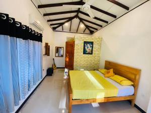 a bedroom with a bed with yellow pillows at Ritigala Hideaway in Habarana