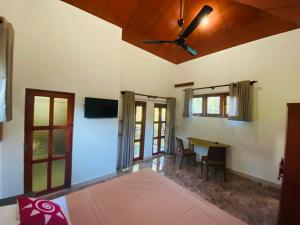 a bedroom with a ceiling fan and a table at Ritigala Hideaway in Habarana