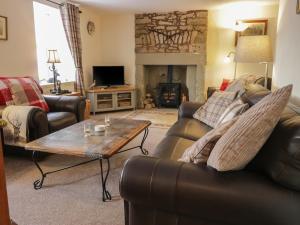 a living room with leather furniture and a fireplace at The Antlers in Coldstream