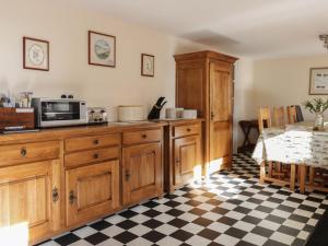 a kitchen with wooden cabinets and a counter with a microwave at The Antlers in Coldstream