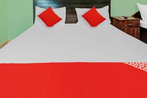 a large bed with red and white pillows on it at OYO 795 Al Karawan Hotel in Dubai