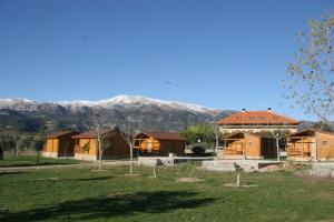 un groupe de maisons avec des montagnes en arrière-plan dans l'établissement Camping Cañones de Guara y Formiga, à Panzano