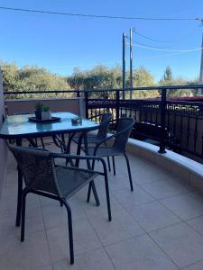 a patio with a table and chairs on a balcony at ATHINAS APARTMENT in Limenas