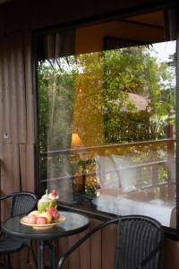 a table with a plate of fruit on a balcony at Baan Krating Phuket Resort -SHA Plus in Nai Harn Beach