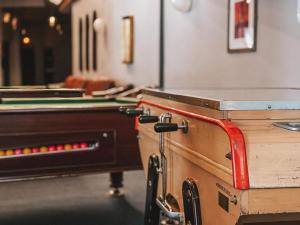 a ping pong table and pool tables in a room at Hôtel Le Montana in La Tania