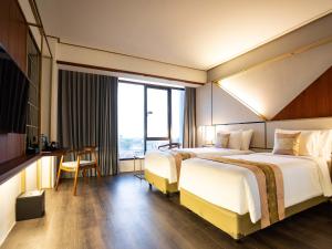 Postel nebo postele na pokoji v ubytování Rayz UMM Hotel Malang